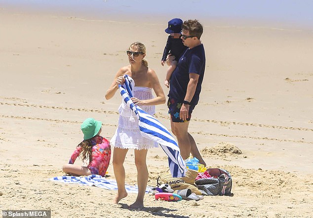 Relaxing: The family laid their towels and bags on the sand and enjoyed the sun before Dec went to work