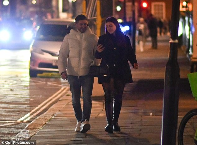 Night out: Her mystery man wore a white padded jacket and jeans, paired with white sneakers