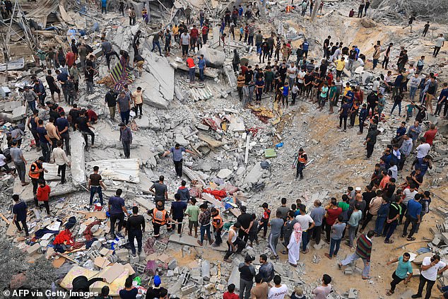 Civilians and rescuers search for survivors amid the rubble of a destroyed building after an Israeli bombardment of Khan Yunis in the southern Gaza Strip on November 12, 2023