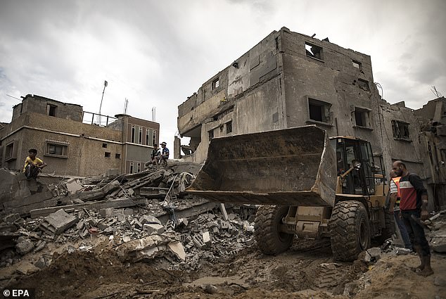 Palestinians search for bodies and survivors among the rubble of a residential building after an Israeli attack in Khan Younis, southern Gaza Strip, on November 12