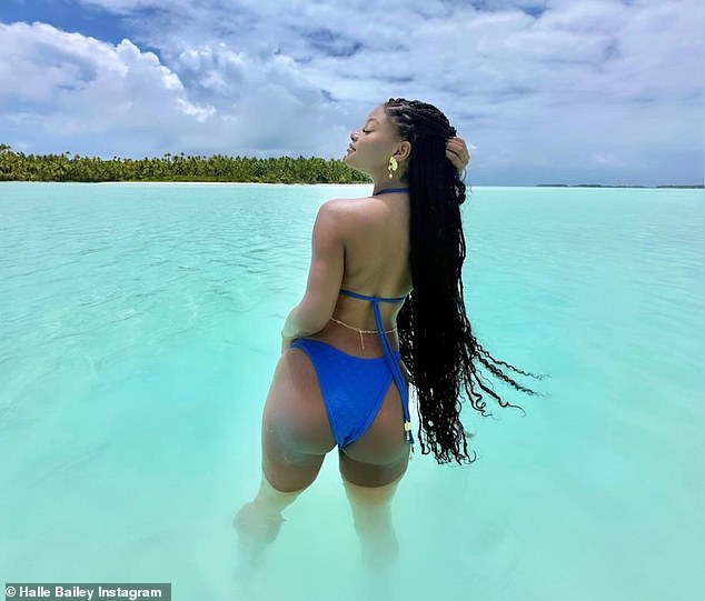 Something to hide?  The Little Mermaid star posed for photos in the crystal clear water showing off her toned bum and slender back, rather than her stomach