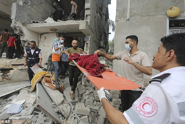 Pictured: Palestinians evacuate a dead child from a building destroyed on Sunday during Israel's bombardment of the Gaza Strip in Rafah