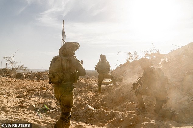 Israeli soldiers take position during the Israeli army's ongoing ground operation against Hamas in the Gaza Strip