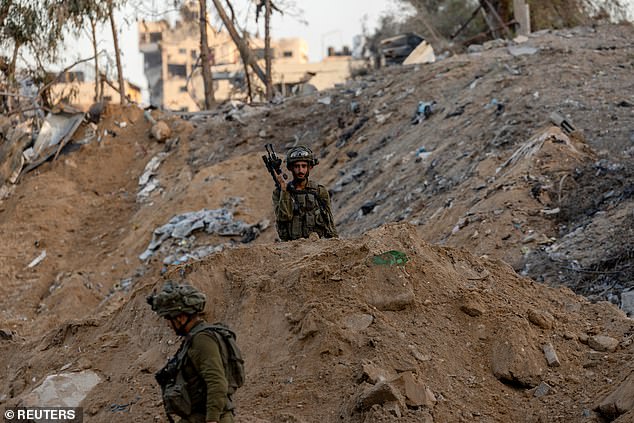 Israeli soldiers walk through the rubble amid the ongoing ground invasion of Gaza