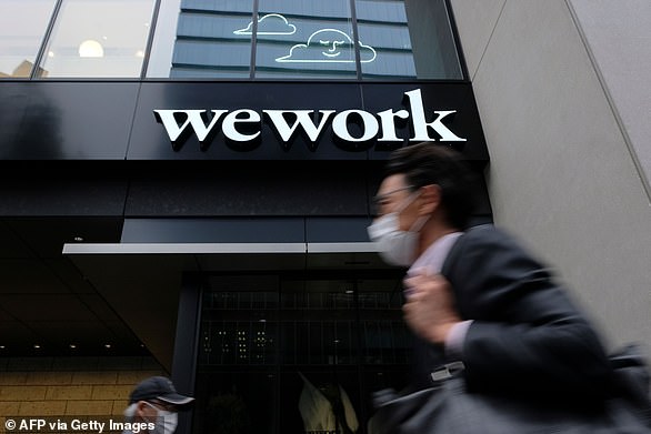 A man walks past the WeWork logo in Tokyo on May 18