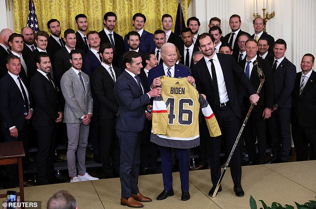 Mark Stone and George McPhee present President Joe Biden with a jersey and a gold hockey stick