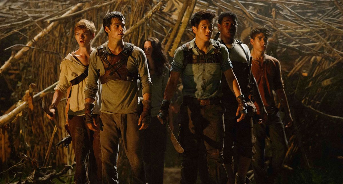 The Maze Runners stand together and look scared in Maze Runner