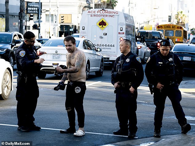 San Francisco officials are seen interacting with a camp resident during their cleanup efforts on Saturday