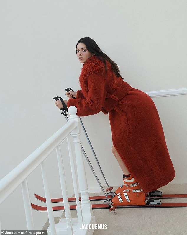 Daring: The skis make a second cameo in a photo of Kendall wearing a furry red coat as she stood at the top of a staircase with poles in hand