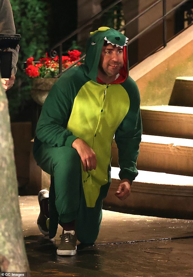 New look: American actor John, who directs and stars in the new fantasy comedy, looked hilarious as he wore a dinosaur onesie for the scenes