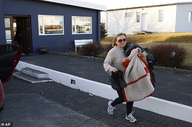 A resident of the town of Grindavik, Iceland, removes some of her belongings from her home after being ordered to evacuate