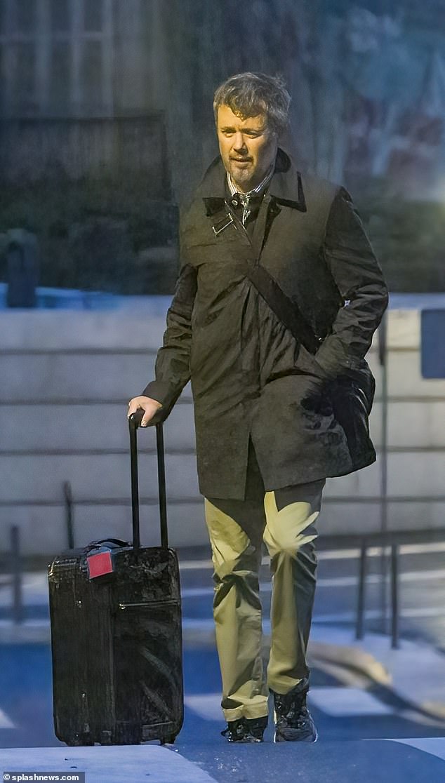 Crown Prince Frederik is photographed at 8:30 the next morning as he leaves an apartment to fly back to Copenhagen