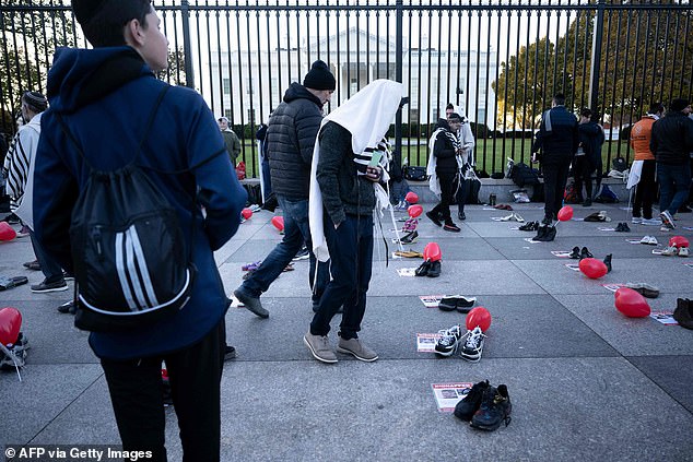 People pray before the rally on Pennsylvania Avenue in front of the White House