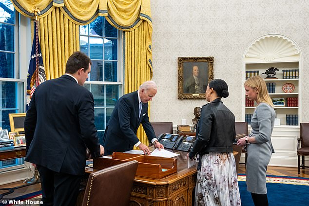 Aides surround President Joe Biden in the Oval Office.  Politico's Jonathan Martin's column said that 