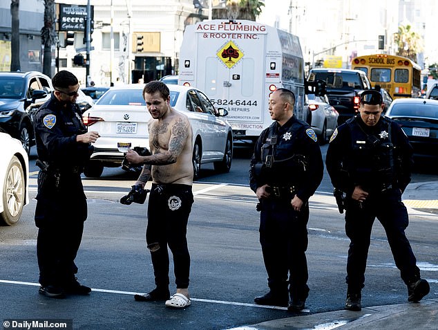 San Francisco officials are seen interacting with a camp resident during their cleanup efforts on Saturday