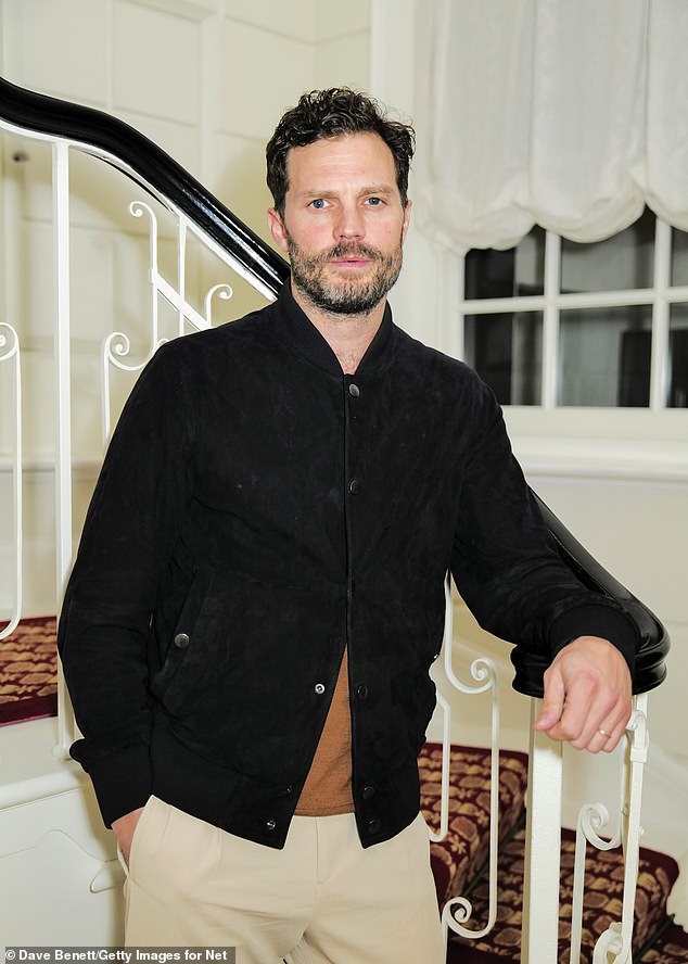 Looking good: Fifty Shades Of Gray star Jamie, 41, cuts a cozy yet stylish figure in a navy blue bomber jacket layered over a brown sweater