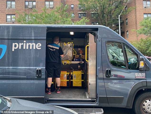 An Amazon Prime delivery person is seen sorting packages in an Amazon van in Queens, New York