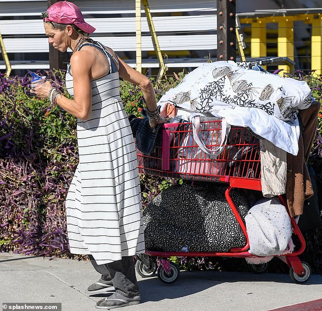 She kept a close eye on her cart, which was filled to the brim with everything from towels to various clothing items like jackets, tops and jeans.