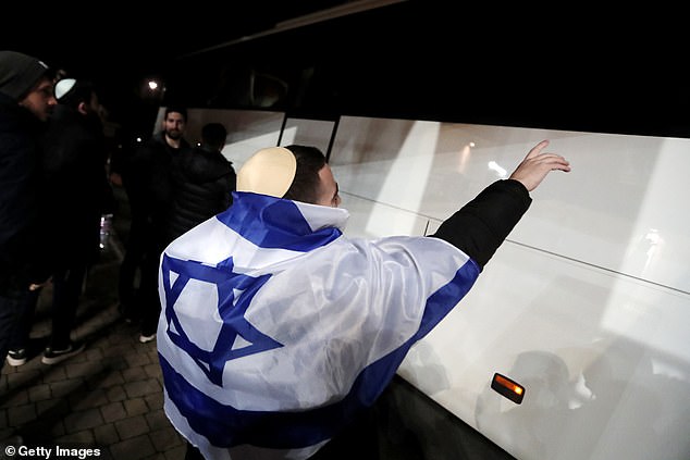 An Israeli fan welcomes their team bus as it arrives at the stadium in Felcsut, near Budapest