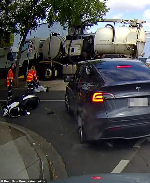 The scooter driver was helped off the ground by two female construction workers while the Tesla driver remained in their vehicle