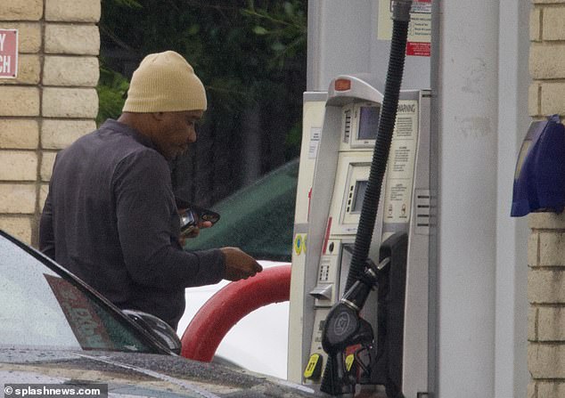 Running errands: Martin was later pictured filling up his car with gas, wearing a tan beanie to keep him warm