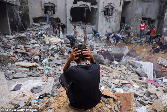 A child reacts as people rescue belongings from the rubble of a damaged building after the attacks on Rafah in the southern Gaza Strip last week