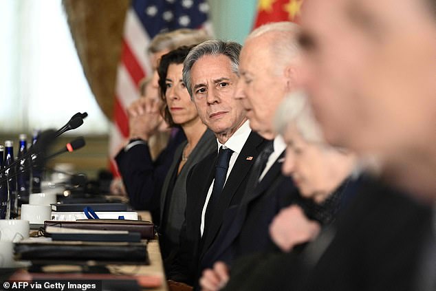 Blinken watches Biden speak as the two sides meet at a table