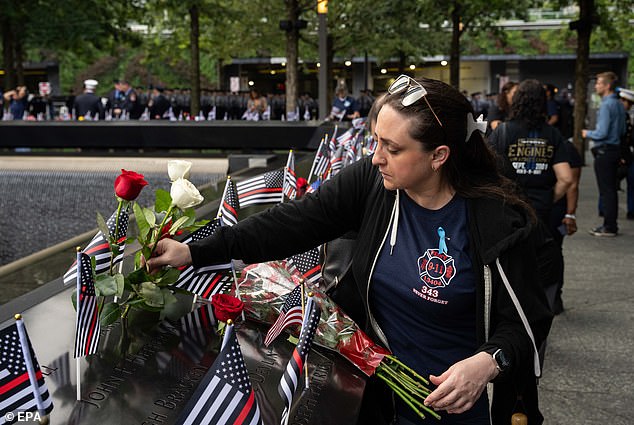Clare Baron lays a rose for her cousin Mark Whitford at the National September 11 Memorial during an annual ceremony commemorating the 22nd anniversary