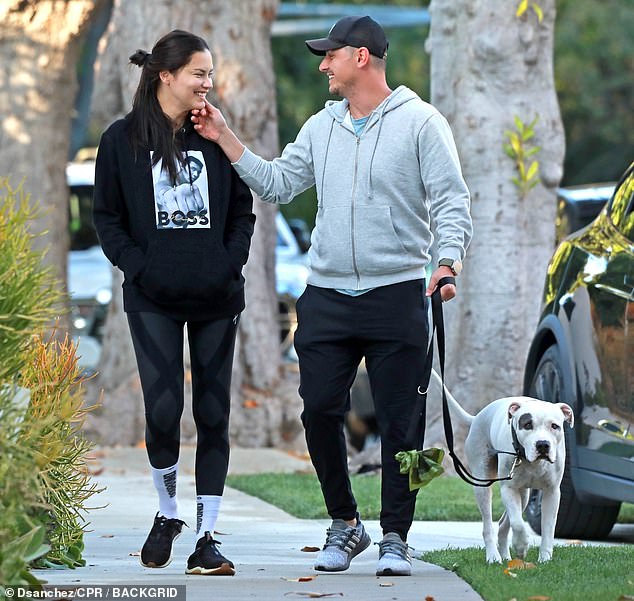 Tender moment: Adriana smiled as Andre lovingly caressed her face while walking the dog