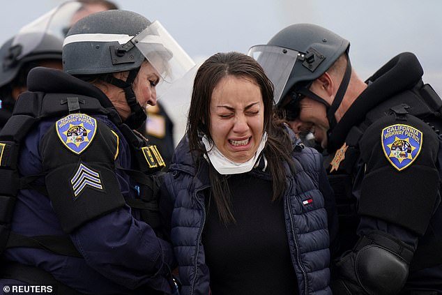 A protester is seen crying as he is arrested after blocking the Bay Bridge and demanding that the US stop sending military aid to Israel