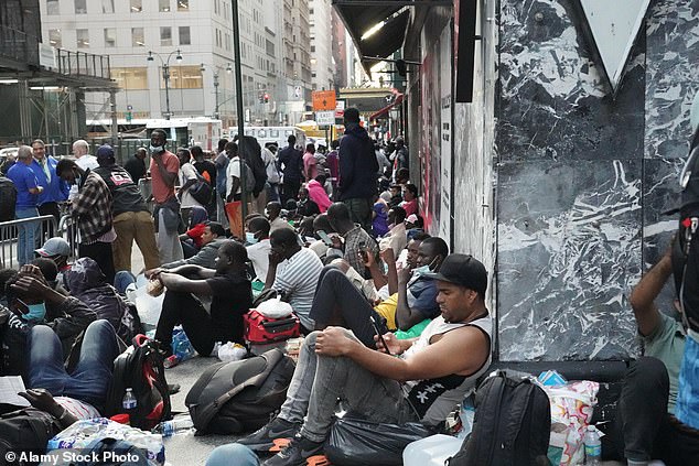 Migrants from Africa, Mexico and Venezuela line up outside the Roosevelt Hotel in Manhattan in August.  The hotel has been given the name 'Ellis Island' because this is where the migrants are processed