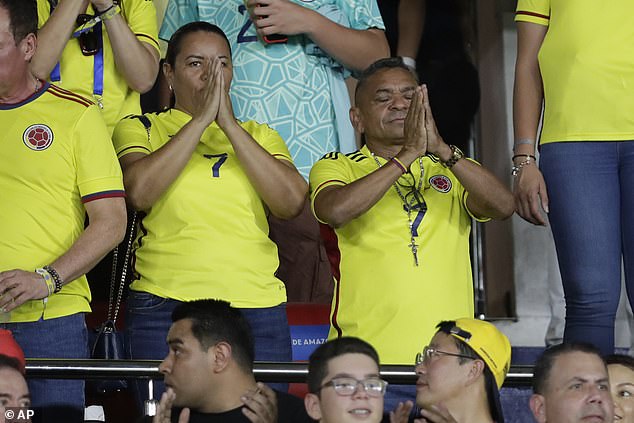 Luis Manuel Diaz (right) and Cinelis Marulanda (left) hold their hands in prayer before the match