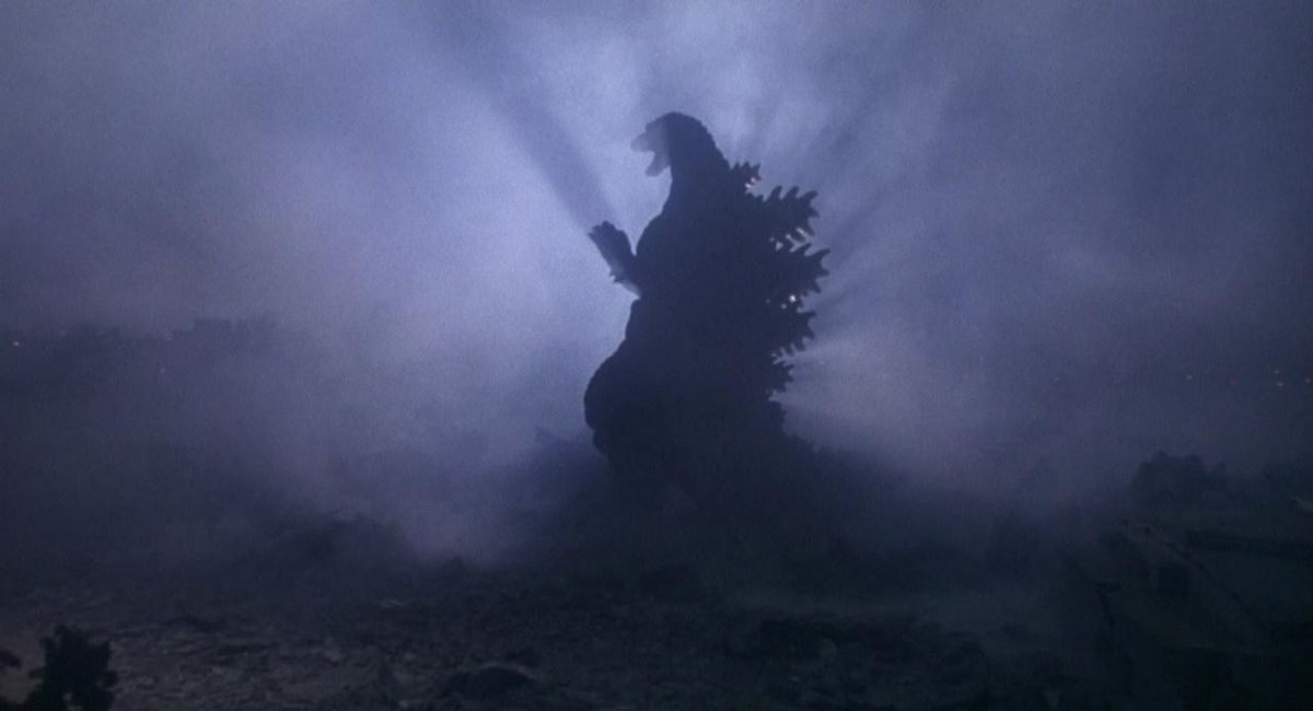 Godzilla in silhouette with a bright light on the other side of him in a still from Godzilla vs. Destoroyah
