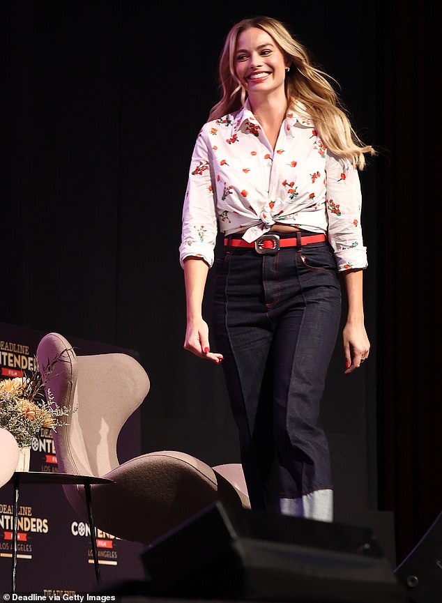 Turning heads: She slipped into a pair of high-waisted dark jeans, which were cuffed at the bottom and secured with a thin, red belt