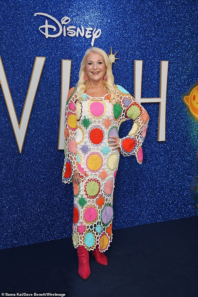 Striking: She turned heads in a brightly colored knitted dress, which she paired with bright pink earrings and bejeweled red boots