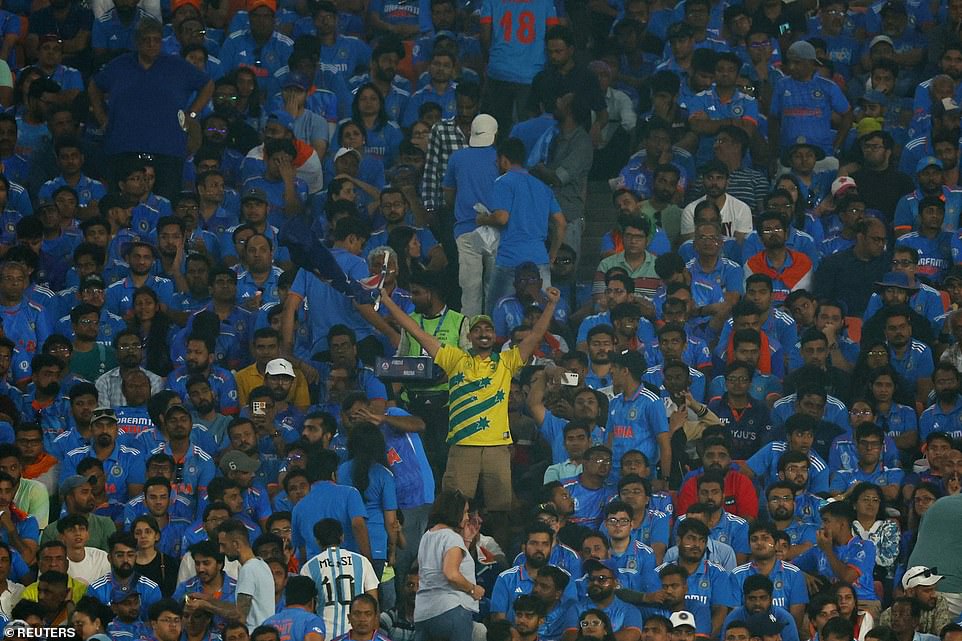 An Australian fan celebrates in a sea of ​​blue as the crowd in Ahmedabad is stunned into silence for much of Sunday's match