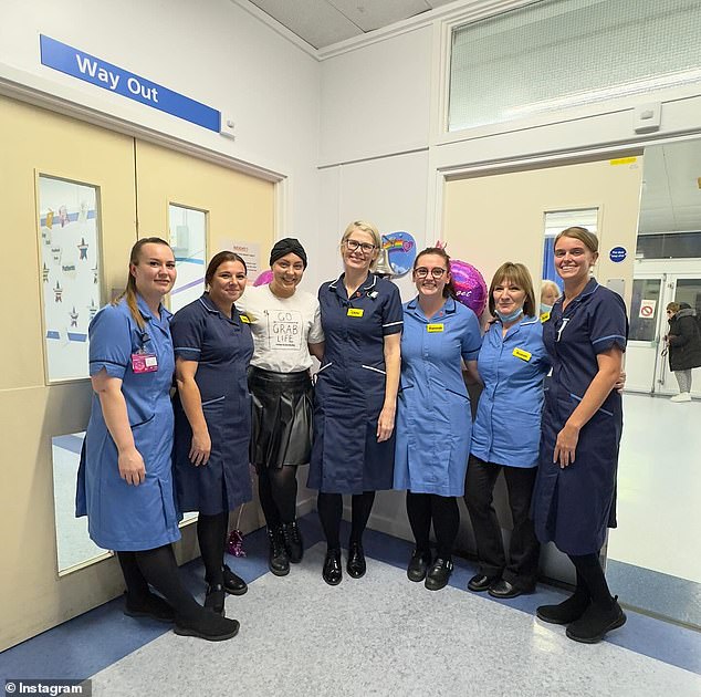 Supportive: Amy beamed for photos with doctors and nurses on the Sheldon Unit as she rang the traditional end-of-treatment bell to celebrate