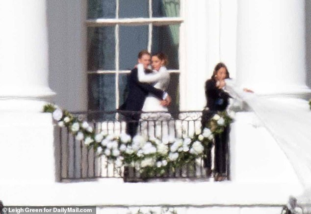 Early images of the couple were seen posing for many photos on the White House balcony as the bride's extremely long train billowed in the wind.