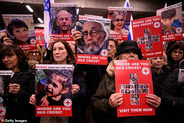 Protesters hold up signs with the faces of some of those believed to be being held hostage by Hamas in Gaza