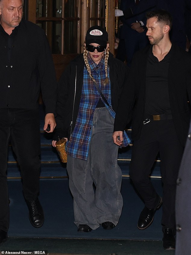 Cool: She also wore a black baseball cap and very baggy gray jeans and smiled as she left the Ritz Hotel, flanked by two bodyguards