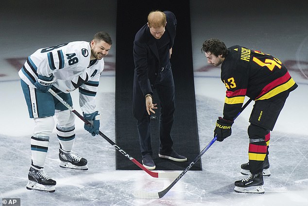 Prince Harry (pictured, center) dropping the puck.  He was reportedly told to throw the puck, according to player Tomá¿ Hertl, who said the Royal simply continued to hold the puck and smiled.