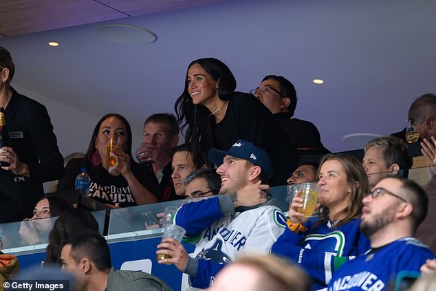 Meghan Markle (photo) smiles as she takes her seat after an exciting moment in the hockey game