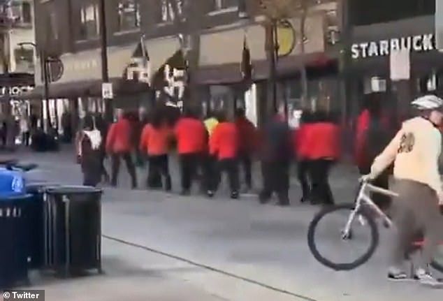 The group proudly waved swastika flags as they marched past a Starbucks branch