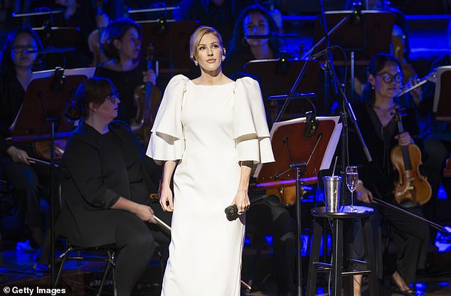 Stunning: The singer, 36, looked perfectly angelic in an all-white ensemble with dramatic sleeves as she took to the stage