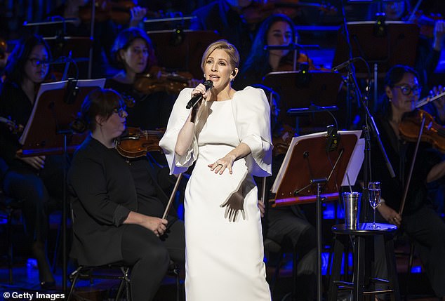 Breathtaking: Ellie showed off her cinched waist in the fitted floor-length gown with exaggerated shoulders and three-quarter sleeves