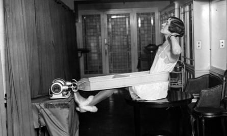 A woman attached to a wall with a vibrating belt