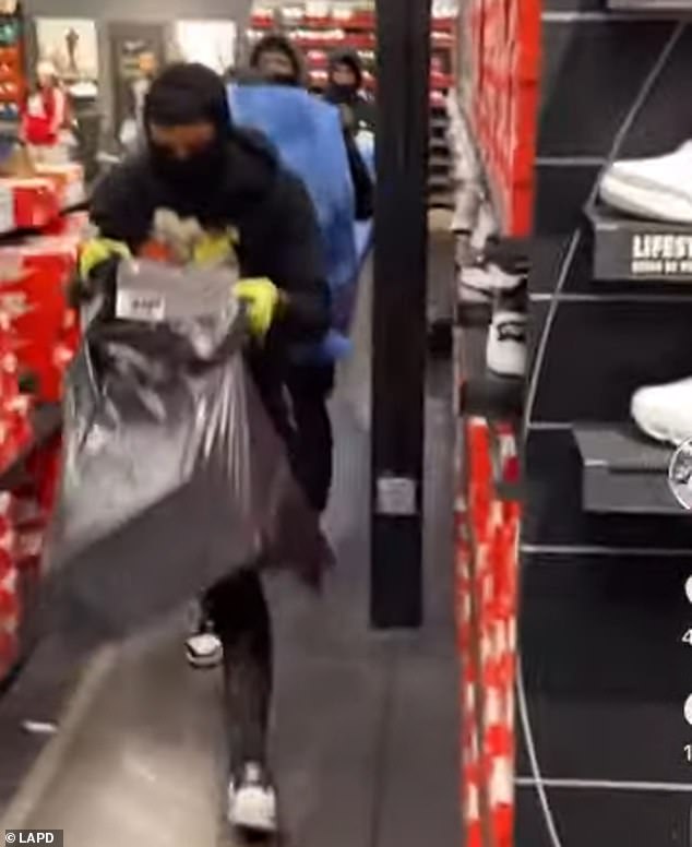 The teens are seen on video filling trash bags with boxes of sneakers and carrying piles of clothing