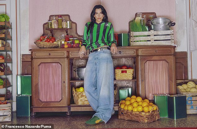 Comfy: She then donned a striped green and blue shirt and baggy jeans as she worked her best angles for the camera