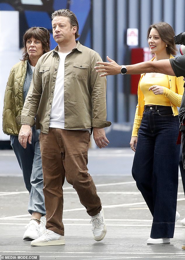 Celebrity chef Jamie Oliver (pictured center) looked warm in earth tones, wearing a tan shirt and brown pants, while Sofia Levin appeared in canary yellow