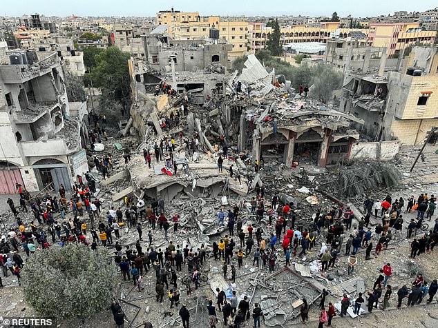 Palestinians search for victims at the site of Israeli attacks on a house in Rafah in the southern Gaza Strip on Wednesday